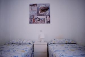 a bedroom with two beds and a picture on the wall at Bungalow Guayana in Mogán