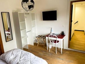 - une chambre avec un bureau et une table avec un ordinateur dans l'établissement La bâtisse des Oves, au Péage-de-Roussillon