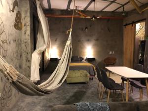 a room with a bed and a hammock in it at Hellen House Bello Horizonte in Santa Marta