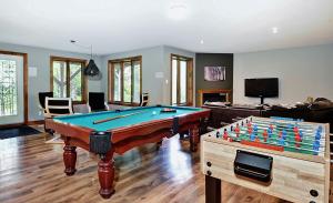 a living room with a pool table and a couch at Chalets Alpins -41 Chemin des Skieurs in Stoneham