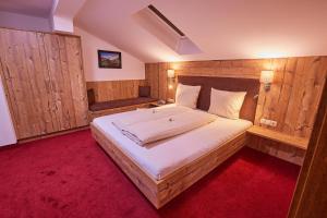 レンゲンフェルトにあるLandhaus Ennemoserの木製の壁のベッドルーム1室(大型ベッド1台付)