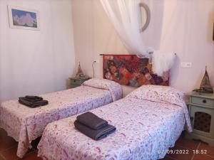 two beds in a room with two towels on them at Casa Picasso in Ítrabo