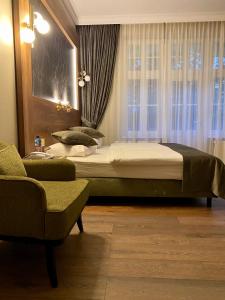 - une chambre avec un lit, une chaise et une fenêtre dans l'établissement Pensjonat - Restauracja Żółty Domek, à Szczecinek