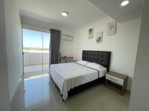 a bedroom with a bed and a glass shower at Condominio Las Palmas II VILLA FATIMA in Santa Cruz de la Sierra