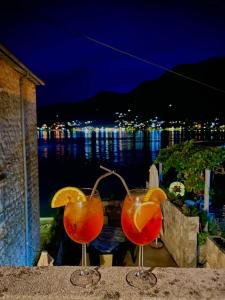 two cocktails sitting on a ledge with a view of the water at Apartment Aleksandar in Tivat