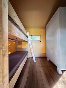 a room with a bunk bed and a staircase at Luxe Lodgetent in Holten