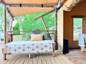 a bed on a porch with a canopy at Luxe Lodgetent in Holten