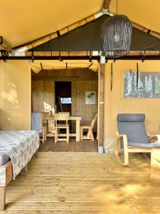 a porch with a bed and a table and chairs at Luxe Lodgetent in Holten