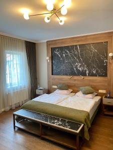 - une chambre avec un grand lit et un grand mur dans l'établissement Pensjonat - Restauracja Żółty Domek, à Szczecinek