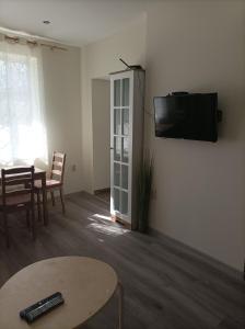 uma sala de estar com uma mesa e uma televisão na parede em Apartment Starfish em Varna City
