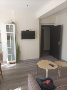 een woonkamer met een bank en een tv aan de muur bij Apartment Starfish in Varna