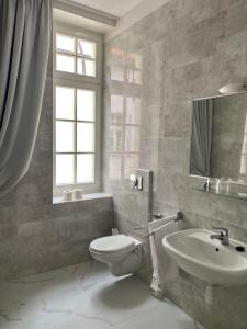 a bathroom with a white toilet and a sink at Pensjonat - Restauracja Żółty Domek in Szczecinek