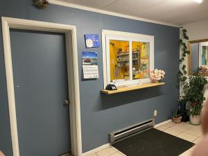 um quarto azul com uma porta e uma janela em Etown Motel em Elizabethtown