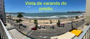 een uitzicht op een straat met auto's geparkeerd op het strand bij Suíte Mar Econômica e Compacta - Praia do Morro - Prédio frente Mar com elevador, atravessou a avenida, já está na Praia - Garagem - Internet in Guarapari