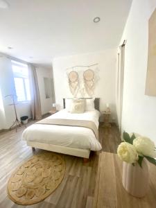 a bedroom with a large bed and a vase of flowers at Chambre Centre Ville Le Blanc in Le Blanc