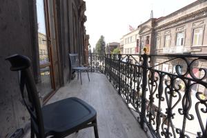 a balcony with a chair and a view of a city at Aratta Royal Hotel in Gyumri
