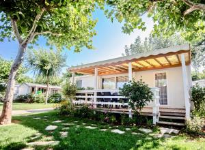 a house with a pergola in a yard at Miramare Camping Village in Sottomarina