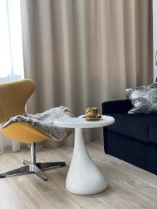 uma sala de estar com uma mesa e um sofá em ALE Jerozolimskie Varsovia Apartments em Varósvia