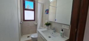 a bathroom with a sink and a toilet and a mirror at Lina House Garden, BBQ & Outdoor Dining in Puntagorda