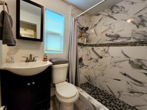 a bathroom with a toilet and a sink at Mermaid's Cottage in West Palm Beach