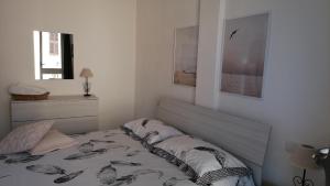 a white bedroom with a bed and a window at Appartamento incantevole con piscina in Palau