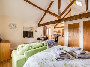 1 dormitorio con 1 cama verde y 1 sofá en The Dairy - Uk10957, en Burlton