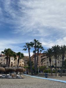 a resort with palm trees and a building in the background at Apartamento con vistas en Mariote in Almuñécar