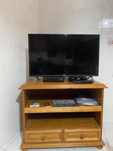 una TV a schermo piatto su un centro di intrattenimento in legno di Casa Fontanelle a Burgio