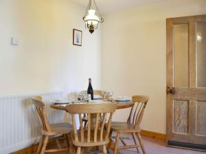 a dining room with a table with a bottle of wine at Swallows Return in Whitehaven