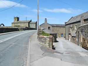an empty street with buildings and a stone wall at Swallows Return in Whitehaven