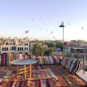 un divano con cuscini e un tavolo sul balcone di Azalea Terrace Hotel a Göreme