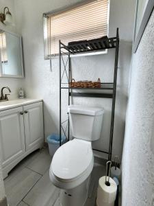 uma casa de banho com um WC branco e um lavatório. em Mermaid's Lighthouse em West Palm Beach