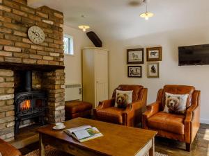 a living room with two chairs and a fireplace at Orchard Barn in Meare