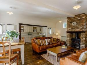 a living room with a couch and a fireplace at Orchard Barn in Meare