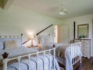 a bedroom with two beds and a mirror at Orchard Barn in Meare