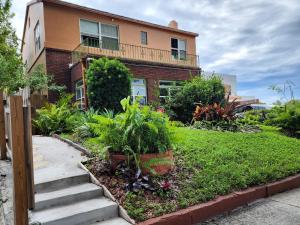 uma casa de tijolos com varanda e algumas plantas em Mermaid's Lighthouse em West Palm Beach