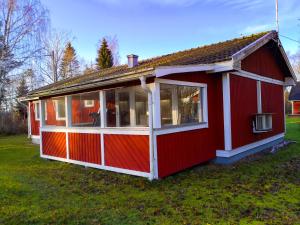una casa roja con muchas ventanas en Ferienhaus Vikeberg in Mittelschweden am Meer, en Hållnäs