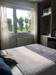 um quarto com uma cama grande e uma janela em Résidence Cosyade équipée d'un parking privé gratuit em Bourbourg
