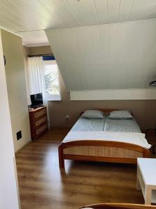 a bedroom with a bed and a television in a attic at Zielony Dom in Węglówka