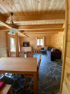 a dining room and living room with a wooden ceiling at Turrach Chalet Haus Dachs in Ebene Reichenau