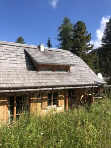 an old wooden house with a tin roof at Turrach Chalet Haus Dachs in Ebene Reichenau