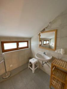 a bathroom with a sink and a mirror and a stool at Turrach Chalet Haus Dachs in Ebene Reichenau