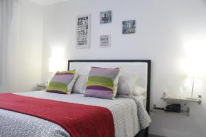 una camera da letto con un letto con cuscini colorati di Hotel Golden House a Barranquilla