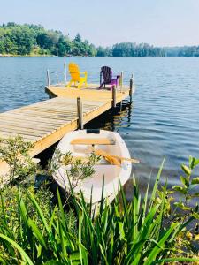 eine Anlegestelle mit zwei Stühlen und einem Boot auf einem See in der Unterkunft Waterfront Splendor in the Woods in Florence