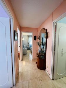 a hallway with a room with pink walls at Acogedor apartamento en Playa San Juan in Alicante