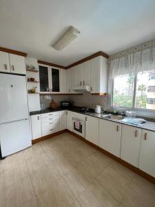 a kitchen with white cabinets and a white refrigerator at Acogedor apartamento en Playa San Juan in Alicante