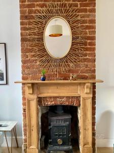a fireplace with a mirror on top of it at Delightful 2 Bedroom House Central Windsor in Windsor