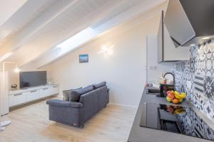 a kitchen and living room with a couch and a television at Maison Cecile in Verbania