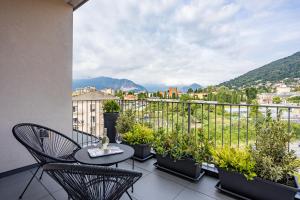 balcón con plantas, mesa y sillas en Maison Cecile, en Verbania