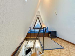 an attic room with a staircase in a house at A beautiful wooden villa for 12 people in Neubukow
